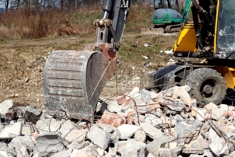 The excavator loads the load on the car. Construction works. Technology of urbanization. Heavy industrial machines. Building of th stock photo The excavator loads the load on the car. Construction works. Technology of urbanization. Heavy industrial machines. Building of th stock photo