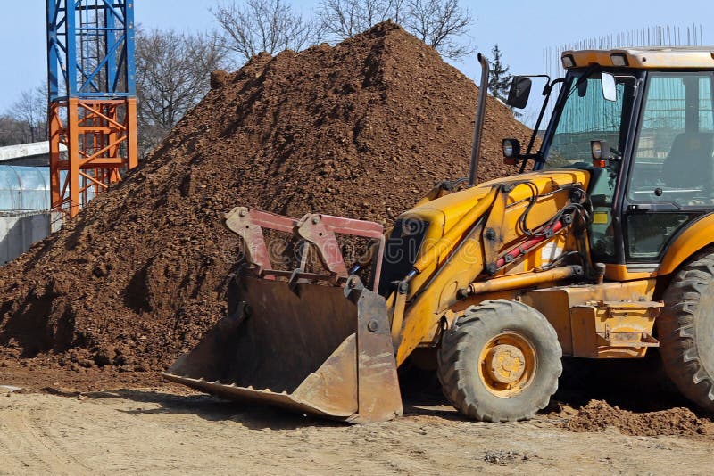 The excavator loads the load on the car. Construction works. Technology of urbanization. Heavy industrial machines. Building of th stock photo The excavator loads the load on the car. Construction works. Technology of urbanization. Heavy industrial machines. Building of th stock photo