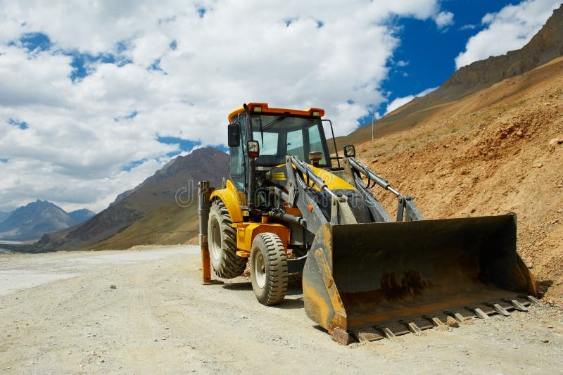 Excavatrice de chargeur de roue au travail de montagnes photo stock Excavatrice de chargeur de roue au travail de montagnes photo stock