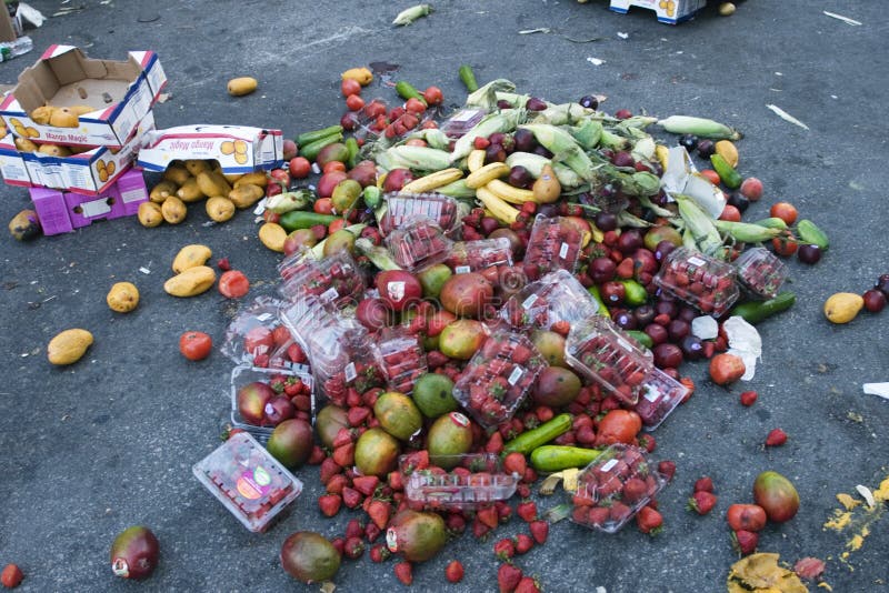 Un mucchio di frutta e verdura buttati su una strada.