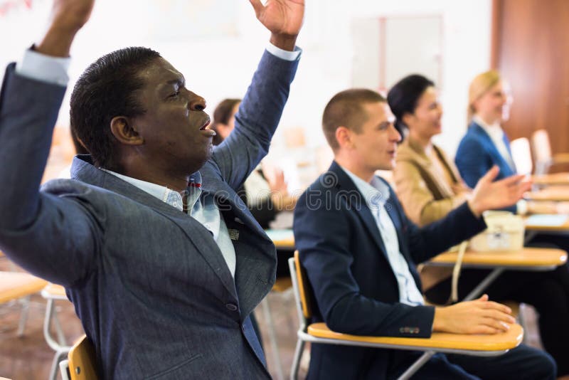 Excited african american man sitting with raised hands during prayer meeting stock photo