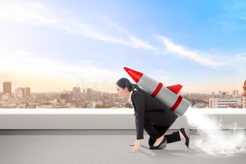 Excited asian business woman on the rooftop with rocket ready to fly royalty free stock photography Excited asian business woman on the rooftop with rocket ready to fly royalty free stock photography