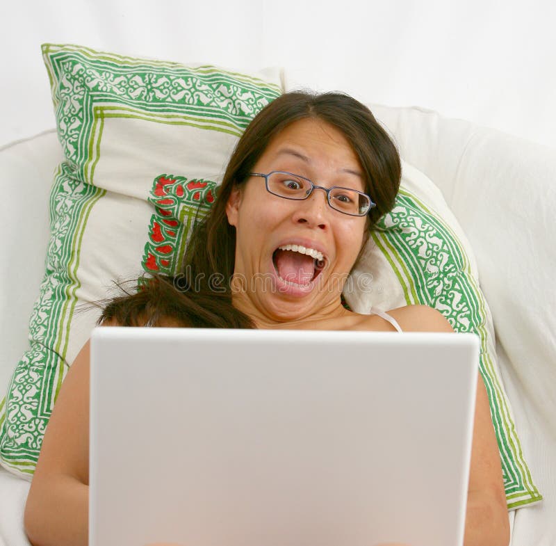 Excited Asian woman on a laptop