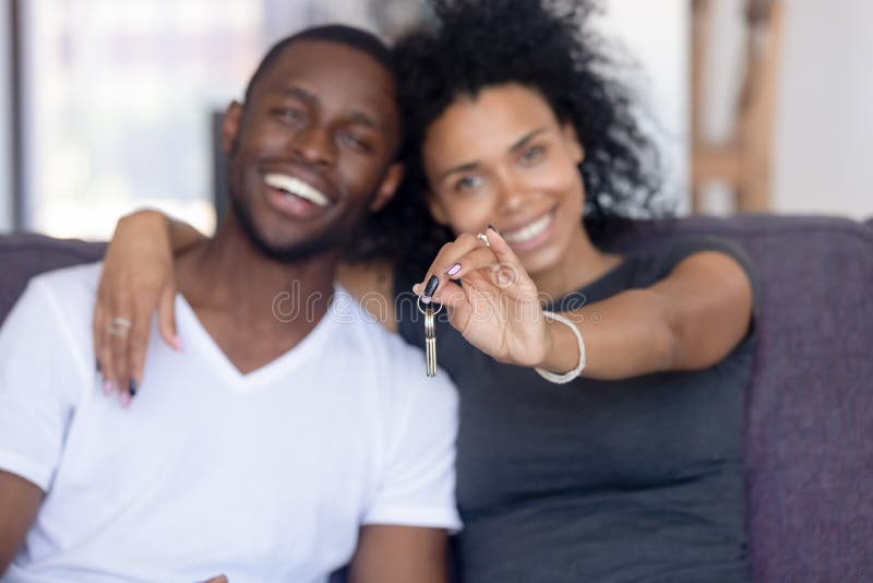 Excited black couple holding keys to first shared home