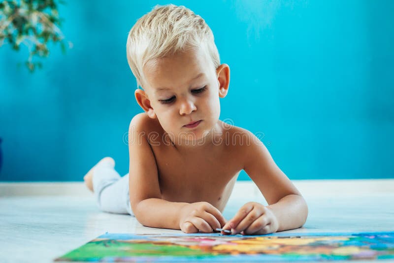Excited boy with an educational puzzle royalty free stock photos