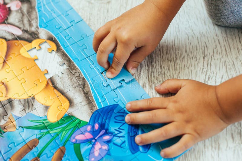 Boy learning how to solve a puzzle stock images.