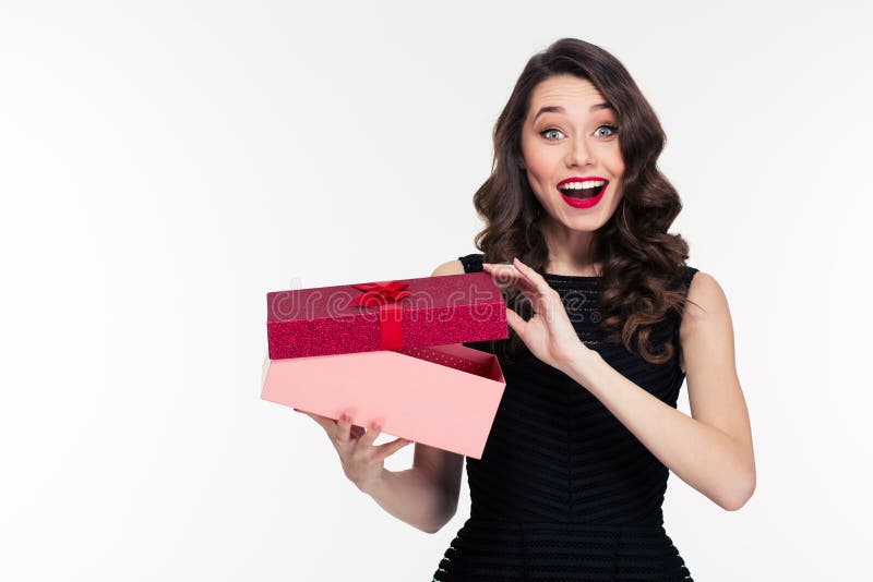 Excited cheerful attractive young woman with retro hairstyle opening gift