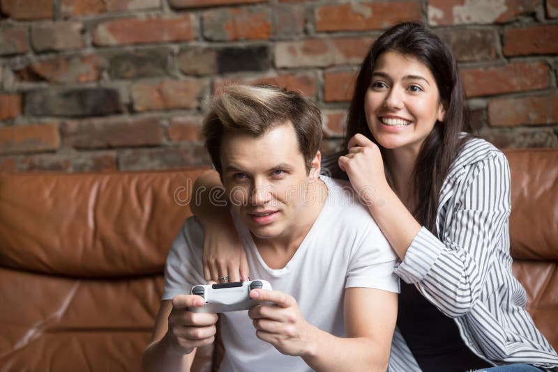 Happy Asian Couple Playing Computer Video Game Sitting On Couch At