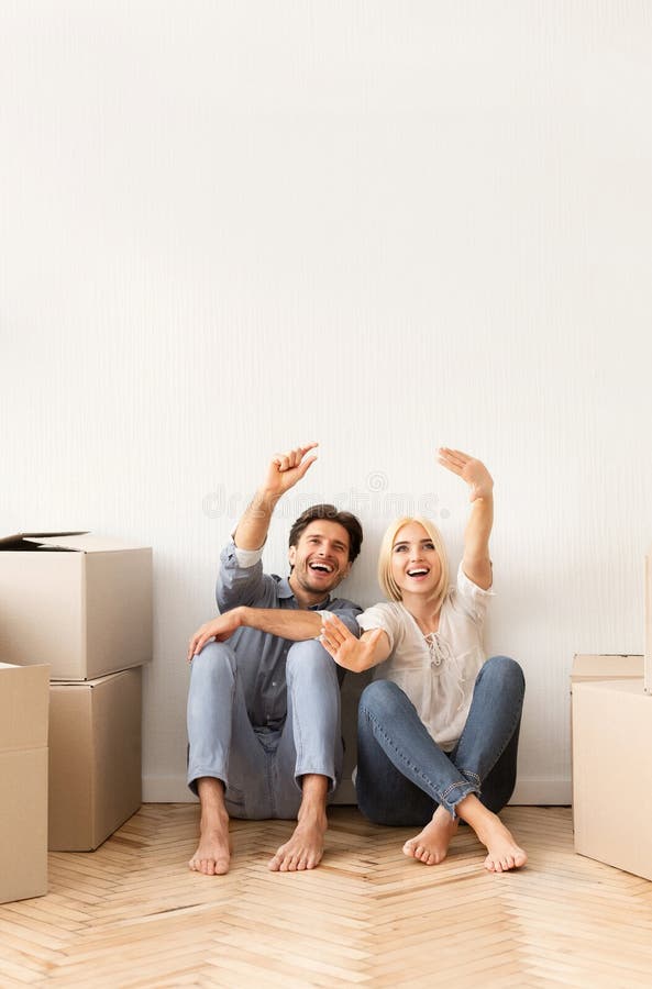 Excited Couple Sitting On Floor Discussing Future Interior Design stock photos Excited Couple Sitting On Floor Discussing Future Interior Design stock photos