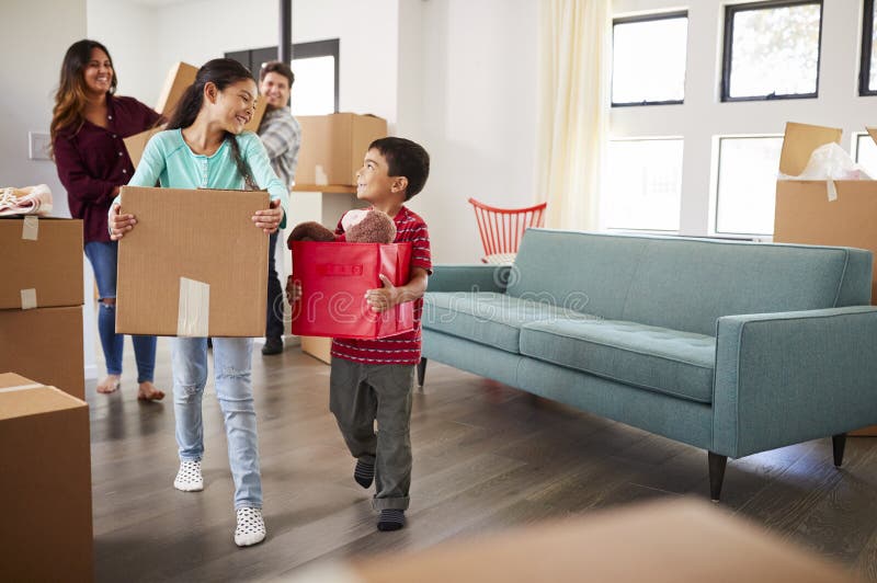 Excited Family Carrying Boxes Into New Home On Moving Day stock image Excited Family Carrying Boxes Into New Home On Moving Day stock image
