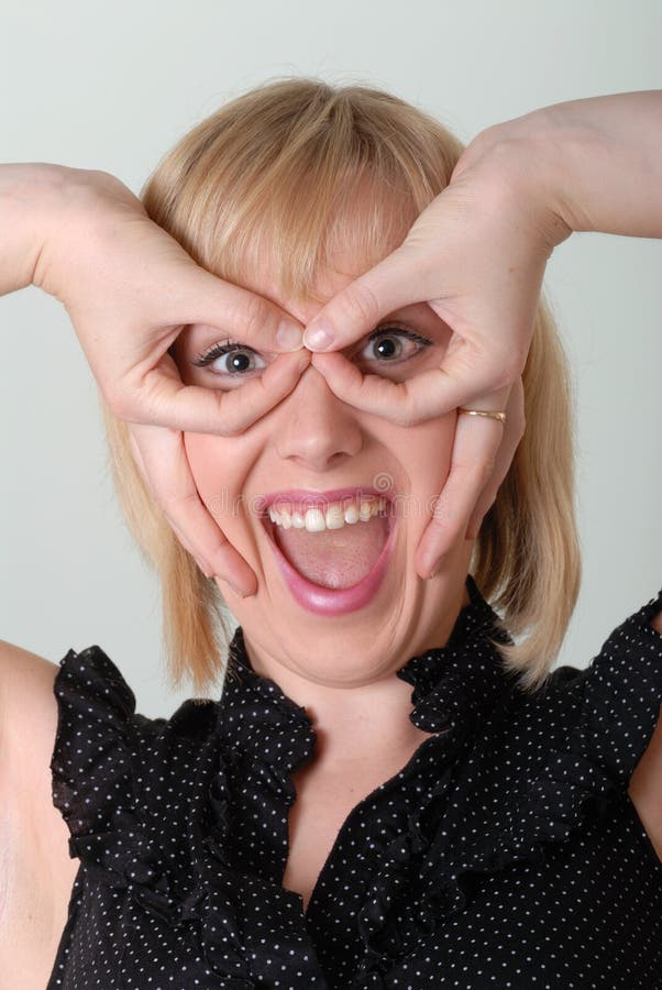 Excited girl makes glasses gesture