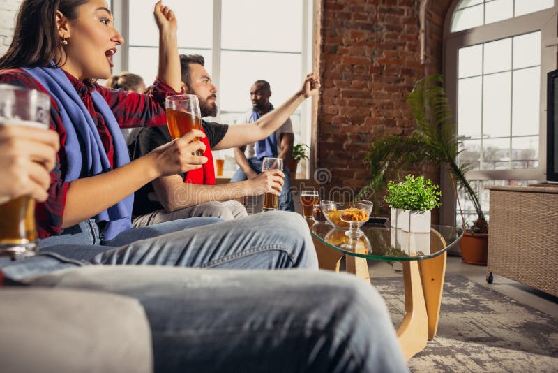 Excited group of people watching football, sport match at home. National, cheerful.