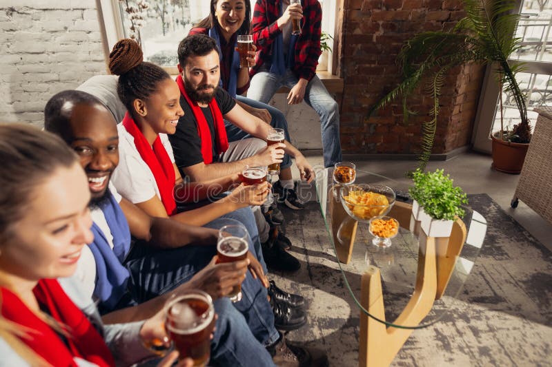 Excited group of people watching football, sport match at home. Happy, entertainment.