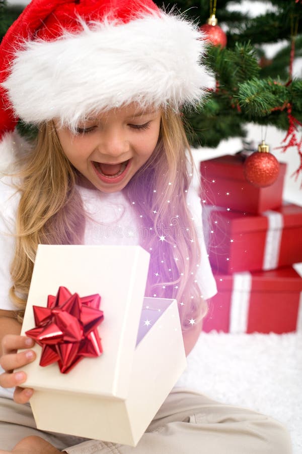 Excited little girl opening christmas present royalty free stock image