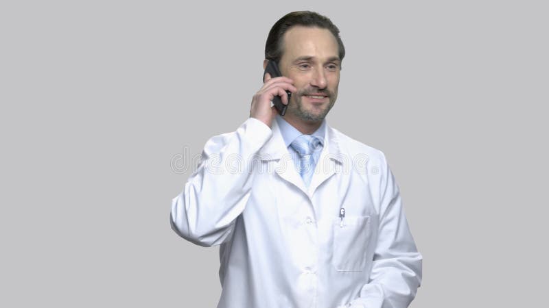 Excited middle-aged physician talking on phone.
