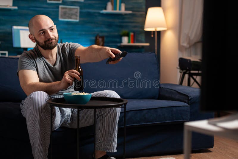 Excited relaxed man spending free time watching TV entertainment series