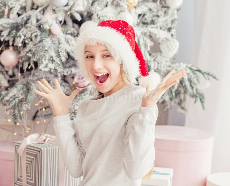 Excited teenage girl near christmas tree