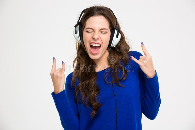 Excited woman in headphones listening to music and gesturing rock royalty free stock image Excited woman in headphones listening to music and gesturing rock royalty free stock image