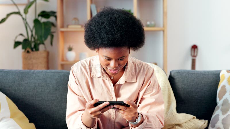 Excited woman playing games on her phone, cheering and celebrating after completing a level. Young female gamer enjoying stock video footage