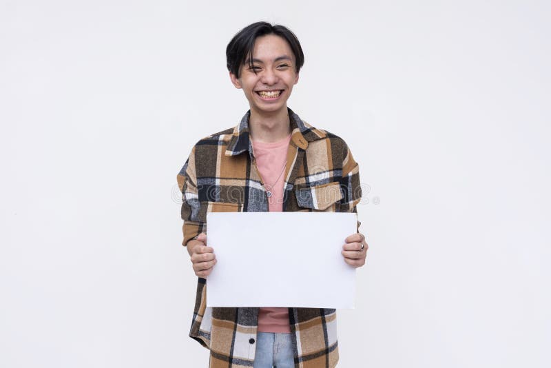 A typical young asian man grinning while holding a blank white signage on a white background royalty free stock image.