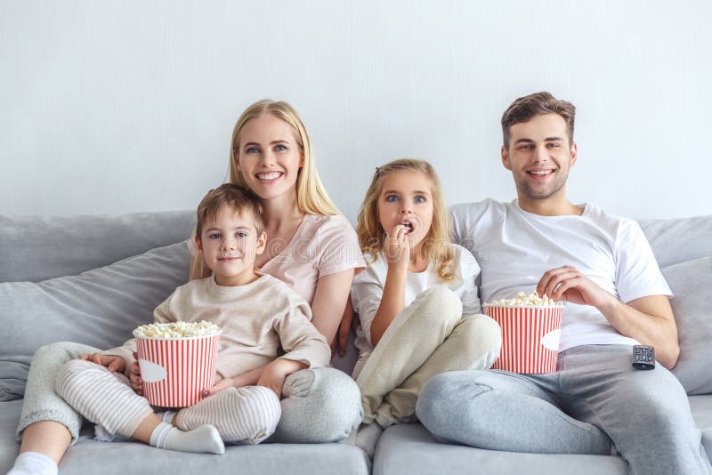 Excited young family watching movie on couch