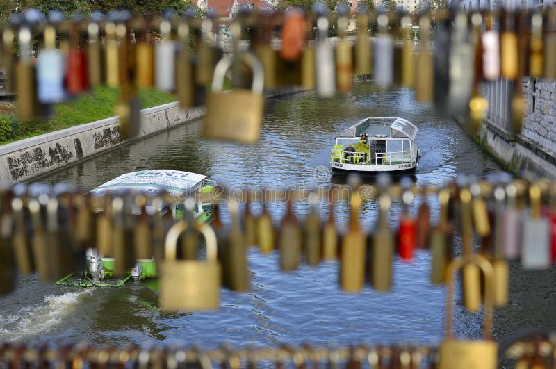 Excursión en el río Ljubljanica sobre el fondo de los candados en el puente foto de archivo Excursión en el río Ljubljanica sobre el fondo de los candados en el puente foto de archivo