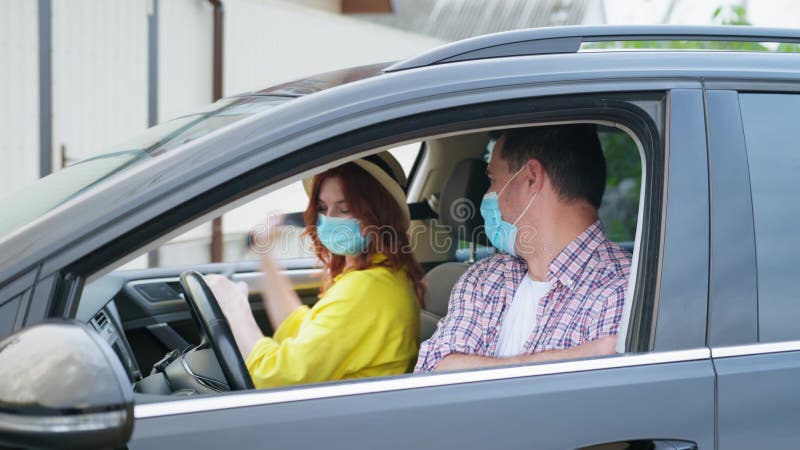 Excursão coronavirus jovem família em máscaras médicas fazendo uma viagem conjunta de carro depois de remover a quarentena