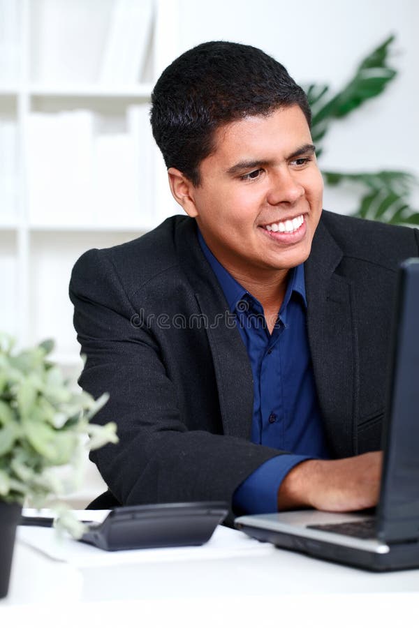 Executivo de sorriso do homem de negócio que usa um computador fotos de stock royalty free Executivo de sorriso do homem de negócio que usa um computador fotos de stock royalty free