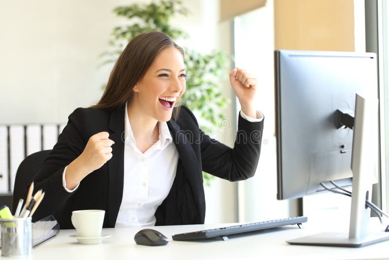 Executivo entusiasmado que olha um monitor do computador imagens de stock Executivo entusiasmado que olha um monitor do computador imagens de stock