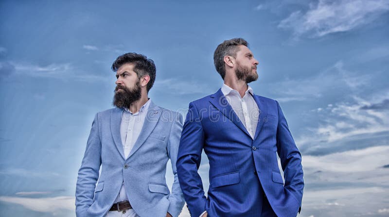 Executivos farpados que levantam seguramente Aperfei?oe em cada detalhe Os homens de neg?cio est?o o fundo do c?u azul Neg?cios fotografia de stock Executivos farpados que levantam seguramente Aperfei?oe em cada detalhe Os homens de neg?cio est?o o fundo do c?u azul Neg?cios fotografia de stock