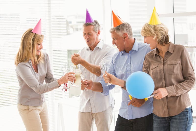 Executivos ocasionais que brindam e que comemoram o aniversário imagem de stock royalty free Executivos ocasionais que brindam e que comemoram o aniversário imagem de stock royalty free