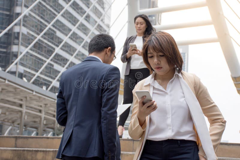 Executivos que guardam o telefone celular e que andam em uma passagem moderna fotografia de stock Executivos que guardam o telefone celular e que andam em uma passagem moderna fotografia de stock