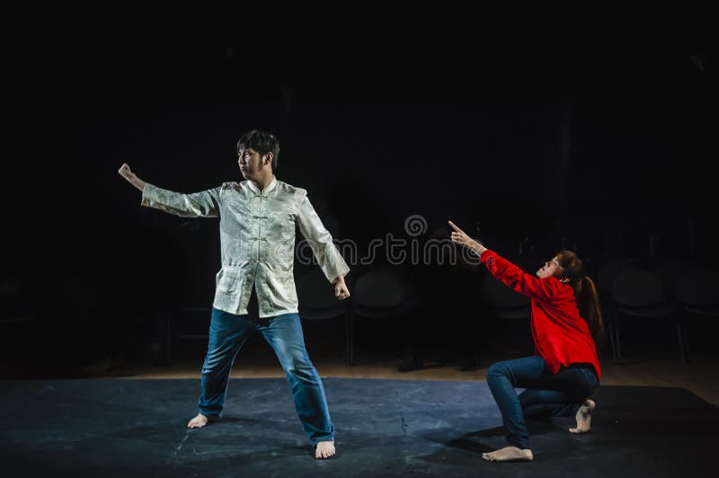 Artistas a atuar no palco num estúdio escuro fotografia de stock