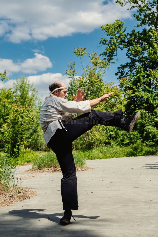 Exercice d'arts martiaux en plein air Une personne qui s'est engagée dans un entraînement dynamique de tir dans un parc photos stock