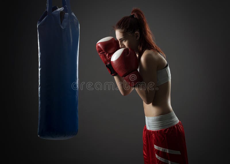 Exercices de femme de boxe avec le sac de sable image stock Exercices de femme de boxe avec le sac de sable image stock