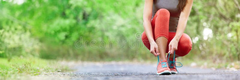 Exercise and sport running shoes runner woman tying laces getting ready for summer run in forest park panoramic banner