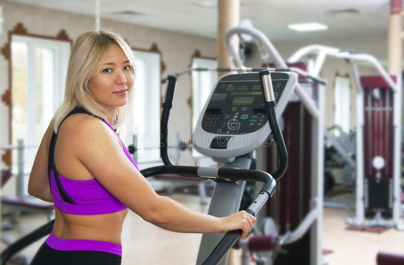 Exercício da aptidão da menina do Gym Menina da aptidão que exercita no equipamento do gym da escada rolante do moonwalker imagens de stock Exercício da aptidão da menina do Gym Menina da aptidão que exercita no equipamento do gym da escada rolante do moonwalker imagens de stock