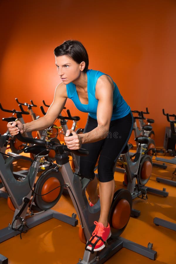 Aerobics spinning woman exercise workout at orange bikes gym. Aerobics spinning woman exercise workout at orange bikes gym