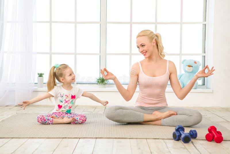 Exercício novo da mãe e da filha junto dentro fotografia de stock Exercício novo da mãe e da filha junto dentro fotografia de stock