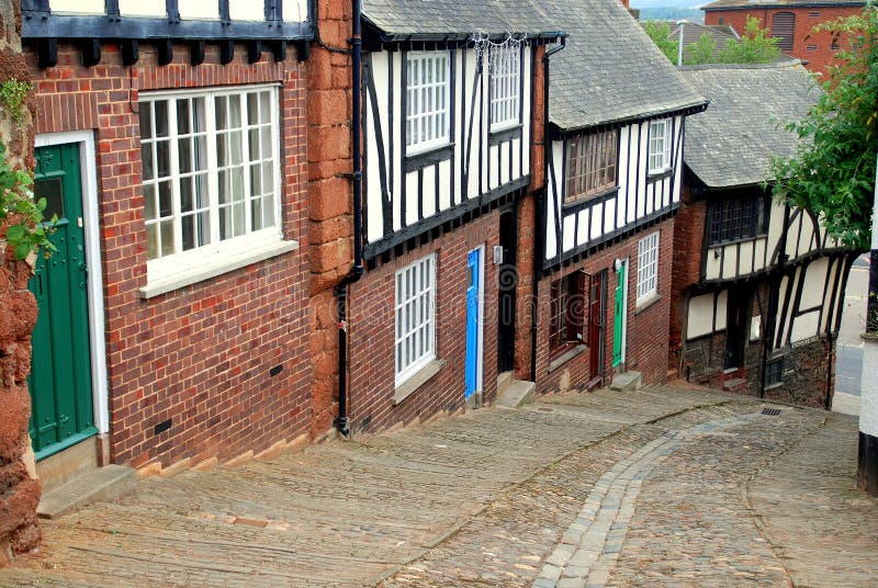 Charming brick and half-timbered houses dating to the 17th century line Stepcote Hill with its cobblestone street in Exeter, England. Charming brick and half-timbered houses dating to the 17th century line Stepcote Hill with its cobblestone street in Exeter, England
