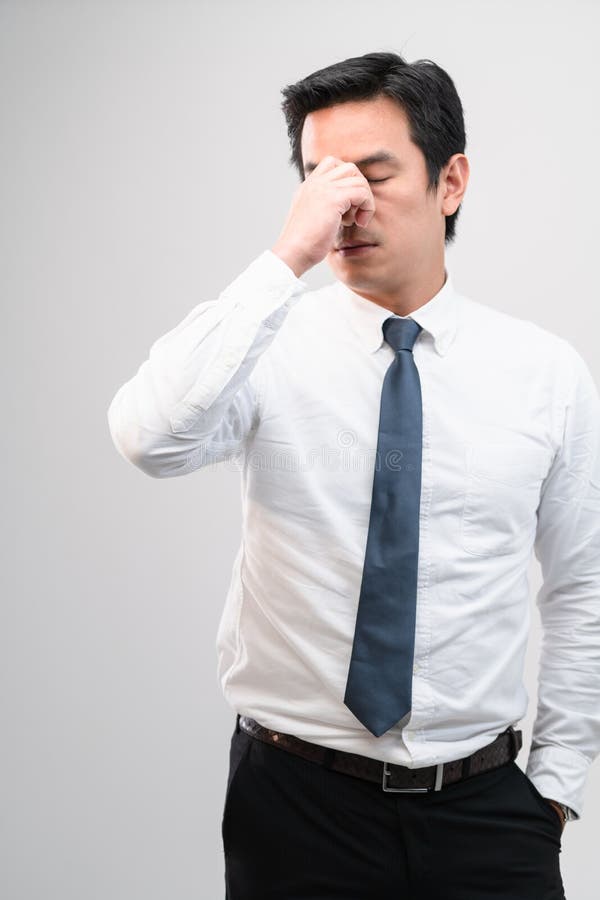 Exhausted Asian Worker Squeezing between the Eyebrows To Try Relaxing