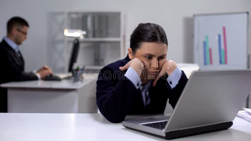 Exhausted female office worker waiting for important e-mail, looking at laptop stock images Exhausted female office worker waiting for important e-mail, looking at laptop stock images