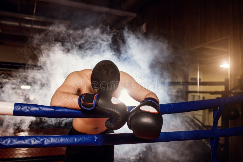 Exhausted man with bowed head down in ring