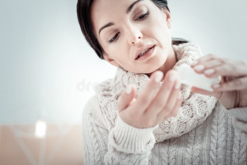 Deep Red Pills And White Bottle On Wooden Background