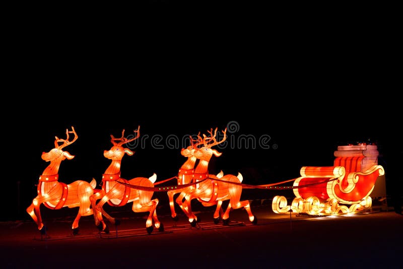 Exhibición decorativa de las luces de la Navidad del invierno del carro de Papá Noel con el reno foto de archivo libre de regalías Exhibición decorativa de las luces de la Navidad del invierno del carro de Papá Noel con el reno foto de archivo libre de regalías