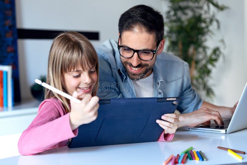Exibição bonita da menina a seu pai a imagem ela apenas que tira na tabuleta digital em casa imagem de stock Exibição bonita da menina a seu pai a imagem ela apenas que tira na tabuleta digital em casa imagem de stock