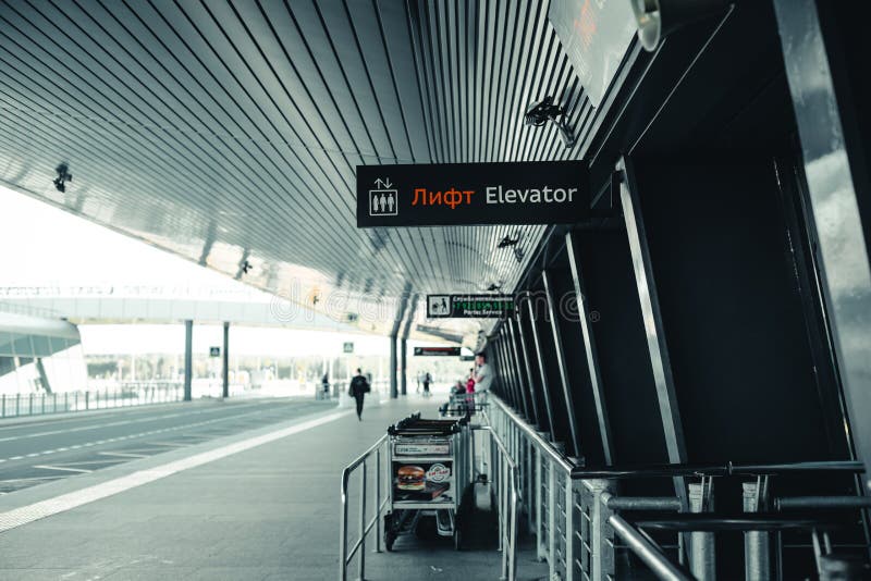 The exit of the airport Pulkovo in Saint-Petersburg-the building of the airport with a signage and Luggage trolleys and the road stock images The exit of the airport Pulkovo in Saint-Petersburg-the building of the airport with a signage and Luggage trolleys and the road stock images