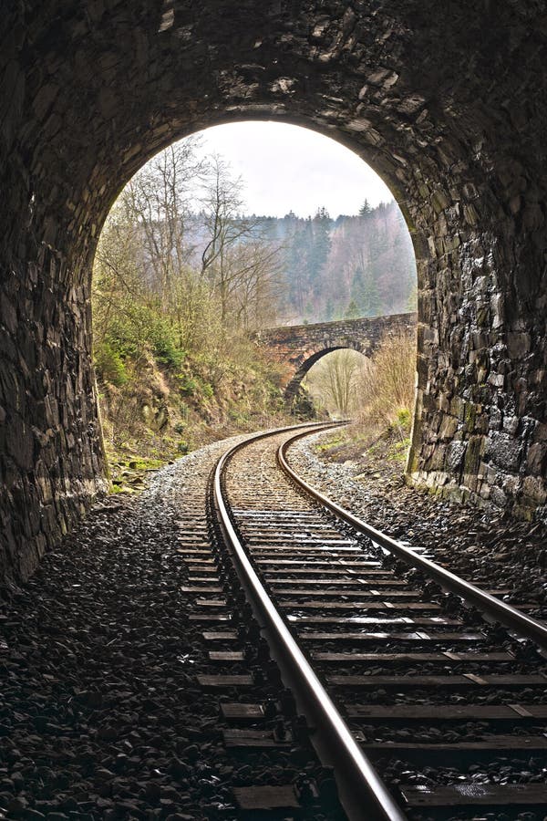 Exit of Vintage train stone tunnel with view on a stone bridge. England style railway travel.