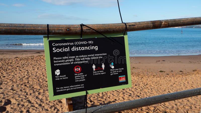 Exmouth, UK - August 03 2020: Coronavirus Covid-19 sign advising Social Distancing at the beach