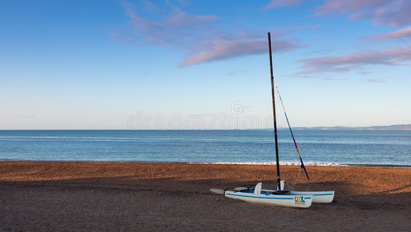 Exmouth, UK - August 03 2020: small catamaran sail boat on Exmouth beach